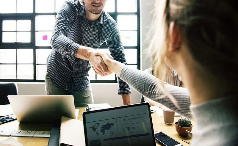 Poignée de main entre deux professionnels qui concluent une entente
